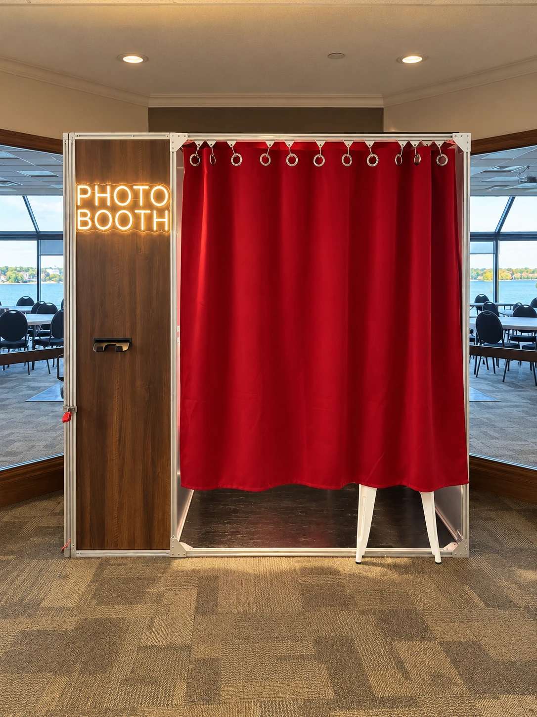 The real Mo's Moments enclosed booth, with a wood-grain cabinet, red curtain and warm PHOTO BOOTH sign