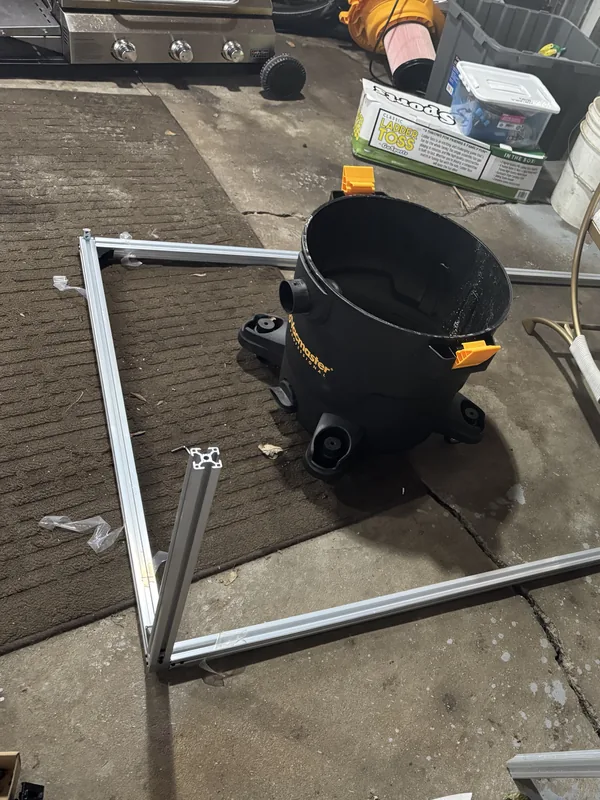 The booth's aluminum base frame laid out on a garage floor
