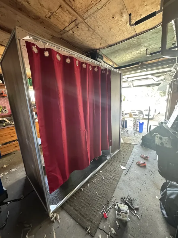 Red curtains hung on ring hangers along the frame