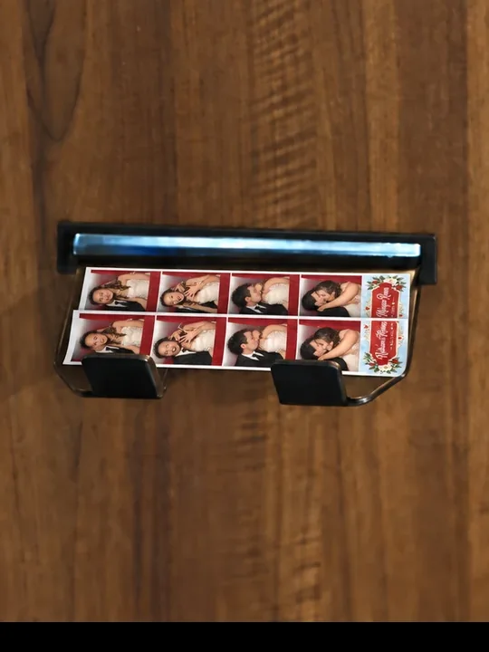 Close-up of the real booth's print catcher holding two matching sample photo strips